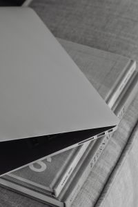 Kaboompics - Laptop and Stacked Books on a Textured Sofa, Close-Up Home Office Detail