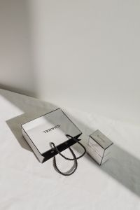 Kaboompics - Chanel Shopping Bag and Perfume Box on White Fabric