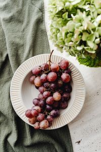 Kaboompics - Red Grapes on a White Plate beside Hydrangeas