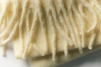 Kaboompics - Close Up of Cream Fringed Scarf for Cozy Seasonal Detail