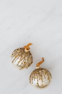 Kaboompics - Gold Glitter Christmas Baubles on White Marble with Generous Copy Space