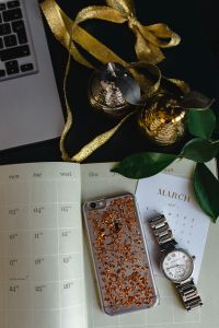 Home office desk with Macbook, iPhone, calendar, watch & organizer