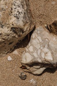 Kaboompics - Veined White Stone Beside Sand and a Weathered Coastal Boulder