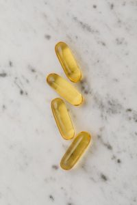 Kaboompics - Four Golden Softgel Capsules on Marble