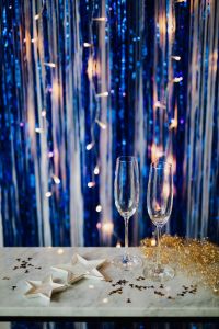 Kaboompics - Empty Champagne Glasses Against Blue Hanging Tinsel Party Background