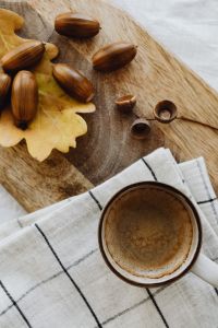 Kaboompics - Coffee Cup with Acorns and Oak Leaves on a Wooden Board
