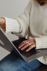 Kaboompics - Faceless Woman in White Sweater Typing on Laptop