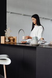 Kaboompics - Pouring Water into a Cup in a Minimal Kitchen