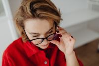 Kaboompics - Close-Up Portrait of Woman Adjusting Eyeglasses at Home Office Desk