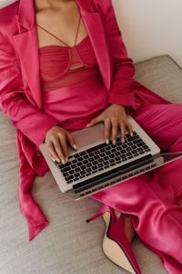 Kaboompics - Close Up Woman Typing on Laptop in Pink Satin Suit
