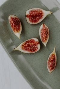 Kaboompics - Macro View of Sliced Fresh Figs on Gray Stoneware Plate, Soft Neutral Breakfast Background