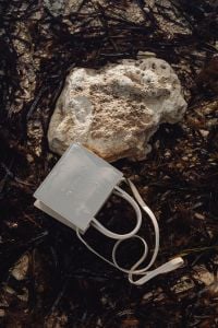 Kaboompics - White Structured Shoulder Bag Against Dark Shore Rocks