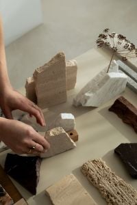 Kaboompics - Hands Styling Architectural Stone Samples on a Neutral Studio Table