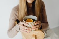 Kaboompics - Woman Holding Tea in a Cozy Chair