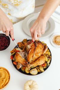 Kaboompics - Hands Carving a Roast Turkey surrounded by Thanksgiving Sides