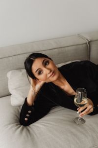 Kaboompics - Woman Looking at Camera While Reclining with White Wine Glass on a Sofa