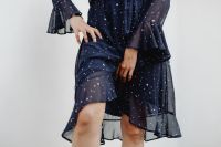 Kaboompics - Cropped Model Wearing Navy Blue Ruffle Dress against White Wall