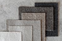 Kaboompics - Stacked Neutral Bouclé Upholstery Fabric Samples on a Gray Stone Surface