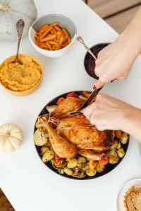 Kaboompics - Knife and Fork Cutting Roast Turkey above Holiday Side Dishes