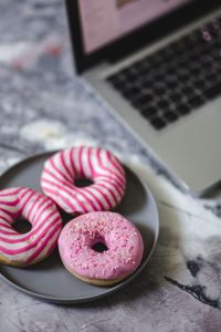 Kaboompics - Pink And Striped Donuts With Laptop Background