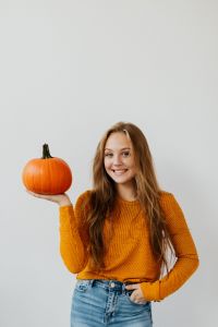 Kaboompics - Young Woman Holding Pumpkin on White Background