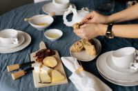 Kaboompics - Hands Sharing Bread at a Cozy Cheese Breakfast