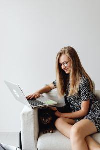 Kaboompics - Young Woman Studying on Laptop with Small Dog