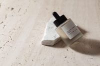 Kaboompics - Close-Up Skincare Serum Bottle on White Stone and Textured Travertine
