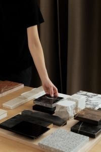 Kaboompics - Hand Placing Black Marble Tile in a Dark Interior Material Arrangement