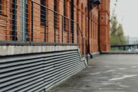 Kaboompics - Metal Mesh Balcony and Industrial Vent Detail on Manufaktura’s Red-Brick Factory Wall