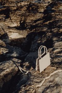 Kaboompics - White Mini Tote Bag Framed by Shadowed Coastal Rocks