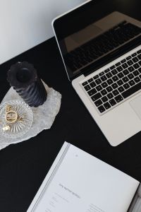 Kaboompics - Laptop, Open Magazine and Black Candle on Dark Desk, Editorial Workspace Flat Lay