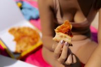 Kaboompics - Person Holding a Pizza Slice Beside a Beach Picnic Box