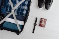 Kaboompics - Travel Packing Flat Lay with Open Suitcase, Sneakers, Passport and Wristwatch