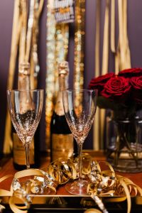 Kaboompics - Champagne Bottles, Flutes, Gold Streamers and Red Roses for New Year's Eve