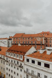 Kaboompics - Pastel Historic Facades and Red-Tiled Roofs beneath a Cloudy Lisbon Sky