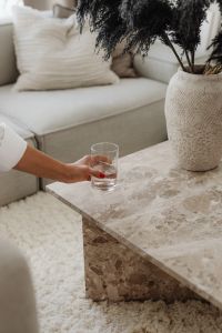 Kaboompics - Hand Holding a Glass Over a Marble Coffee Table