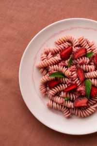 Kaboompics - Strawberry Pasta Plate With Coral Tablecloth and Copy Space