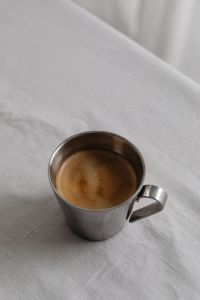 Kaboompics - Chrome Coffee Cup and Spoon on White Tablecloth