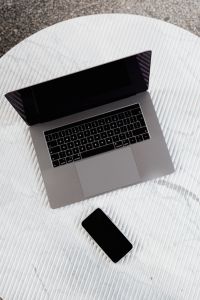 Kaboompics - Angled Silver Laptop with Black Smartphone on Striped Marble, Minimal Digital Workspace