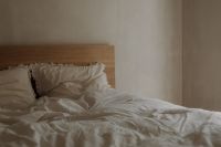 Kaboompics - Unmade White Bed with Rumpled Bedding and Neutral Wall Copy Space
