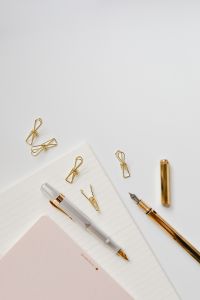 Minimalist Office Stationery Flat Lays with Fountain Pens, Gold Paper Clips and Notebooks on a White Desk