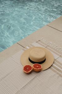 Kaboompics - Poolside Summer Still Life with Grapefruit, Striped Towel and Straw Hat