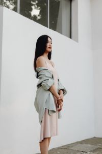 Kaboompics - Side Profile Woman in Pale Dress and Loose Gray Jacket against White Wall