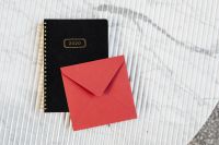 Kaboompics - Red Envelope on Black 2020 Planner, Striped Marble Stationery Flat Lay