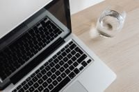 Kaboompics - Laptop and Glass of Water on Wooden Desk