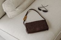 Kaboompics - Brown Woven Handbag and Sunglasses on a Beige Sofa