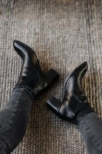 Kaboompics - Black Leather Ankle Boots in Diagonal Fashion Detail on Woven Rug