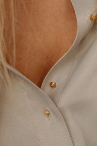 Kaboompics - Gold Buttons on Tan Silk Shirt Close-Up