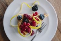 Kaboompics - Berry Cheesecake Slice with Lemon Peel and Mixed Berries